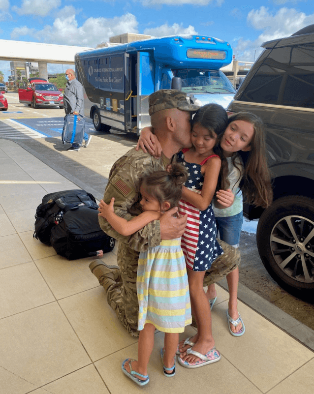 Benito hugs his three daughters before his deployment.